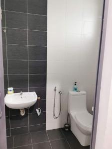 łazienka z toaletą i umywalką w obiekcie EMERALD VILLA HOMESTAY DUNGUN w mieście Batu Lima