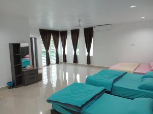 a living room with two beds and a mirror at EMERALD VILLA HOMESTAY DUNGUN in Batu Lima
