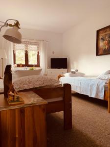 1 dormitorio con 2 camas y mesa. en Restauracja Pensjonat Buda, en Krosno