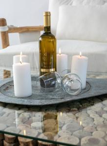 szklany stolik z butelką wina i świecami w obiekcie Luxury Santorini Villa Villa Elysian Dyo Private Hot Tub Air Conditioning 1 Bedroom Oia w mieście Foinikiá +13 zdjęć