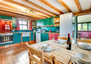 a kitchen with a wooden table with a bottle of wine at Cae Ceiniog in Dolgellau