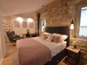 Luxury rooms Prestige Palace في سبليت: غرفة نوم بسرير كبير وجدار حجري
