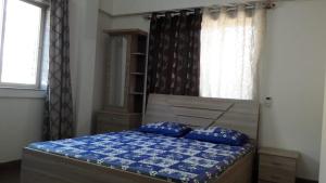 uma cama com almofadas azuis num quarto em Dinoos Sea View em Malvan