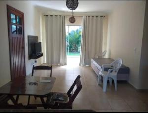 - un salon avec un lit, une table et des chaises dans l'établissement Apartamento próximo Arena Axé Moi, à Porto Seguro