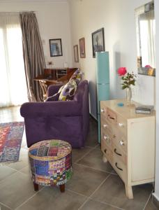 ein Wohnzimmer mit einem lila Sofa und einem Tisch in der Unterkunft House of Hathor in Luxor