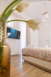 een slaapkamer met een bed en een vaas met een bloem bij Light Garden in Taormina