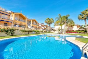 una piscina en una villa con palmeras en Casa en playa con piscina Novamar, en Santa Pola