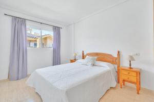 Un dormitorio blanco con una cama y una ventana. en Casa en playa con piscina Novamar, en Santa Pola 16 fotos más