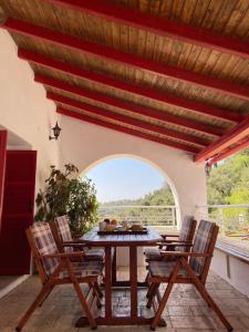 a patio with a table and chairs and an archway at Villa Chrysoula in Kalami