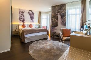 a hotel room with a bed and a chair at Cascada Boutique Hotel in Lucerne