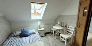 a small bedroom with a bed and a table at Azak in Sarbinowo