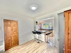 eine Küche mit einer Theke und Hockern in einem Zimmer in der Unterkunft Spacious 3-Bed House with car park near Heathrow in Hounslow