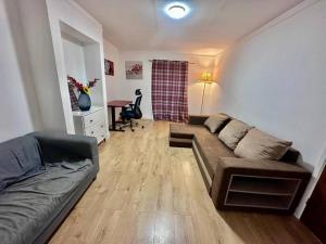 a living room with a couch and a table at Spacious 3-Bed House with car park near Heathrow in Hounslow