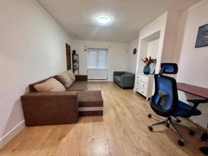 a living room with a couch and a chair at Spacious 3-Bed House with car park near Heathrow in Hounslow