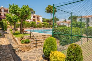 een resort met een zwembad en een hek bij M-4 Calella de Palafrugell 4 PAX in Palafrugell