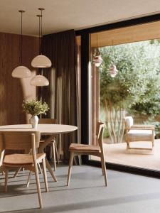 jadalnia ze stołem, krzesłami i lampkami wiszącymi w obiekcie nancy's Holiday Homes Dolomites w mieście Rasun di Sotto