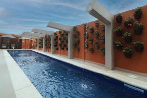 a hotel swimming pool with potted plants on the wall at Culiacan Marriott Hotel in Culiacán