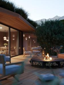 a patio with a fire pit and a table and chairs at nancy's Holiday Homes Dolomites in Rasùn di Sotto