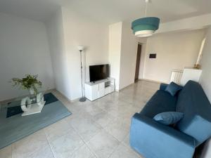 a living room with a blue couch and a tv at Casa Vacanze Le Tre Scimmiette in Paterno