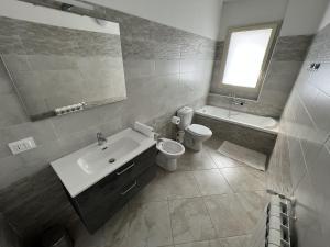 a bathroom with a sink and a toilet and a mirror at Casa Vacanze Le Tre Scimmiette in Paterno