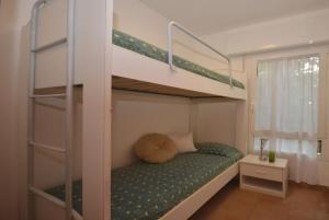 リニャーノ・サッビアドーロにあるVillaggio Lauraのベッドルーム1室(二段ベッド2台、緑色のベッドカバー付)