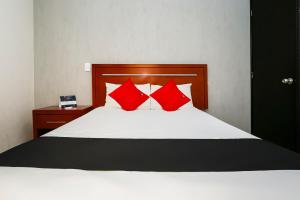 a bedroom with a bed with red pillows at Capital O Hotel Victoria Morelia in Morelia