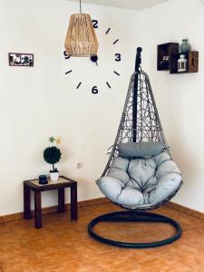 Pokój z huśtawką i zegarem na ścianie w obiekcie Casita A Pitisa w mieście Playa Blanca