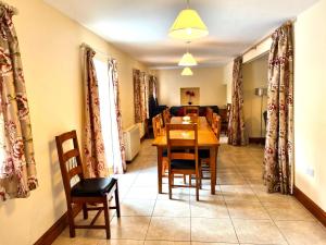 a dining room and living room with a table and chairs at Kestrel Farmhouse in Llandovery