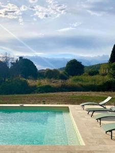 a swimming pool with chairs and a view of a mountain at Grande villa de vacances avec piscine - 6 chambres in Cesseras