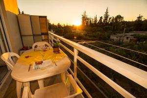 a table and chairs on a balcony with the sunset at Kiki's Cozy Casa in Souda