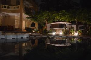 a house with a swimming pool at night at House of Hathor in Luxor
