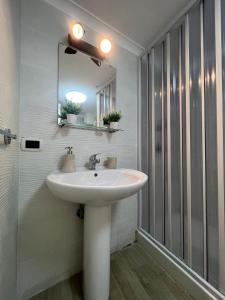 La salle de bains est pourvue d'un lavabo blanc et d'un miroir. dans l'établissement Casa Vacanza , Marianna, à Naples
