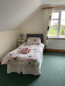 a bedroom with a bed with a floral bedspread at Hillside House - Ringfort in Ballinamuck
