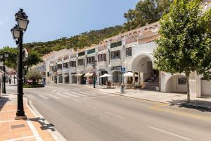 eine leere Straße in einer Stadt mit Gebäuden in der Unterkunft Duplex with sunny terrace located in Mijas Pueblo in Mijas