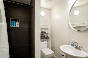 a bathroom with a sink and a toilet and a mirror at Historic Downtown Loft with Modern Flare in Knoxville +43 photos