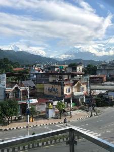 a city with a town with mountains in the background at Bergauf Apartment in Pokhara