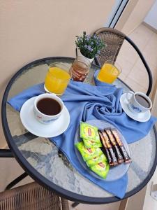 einen Tisch mit blauer Serviette und zwei Tassen Kaffee in der Unterkunft Lydia's cozy house in Paradeísion