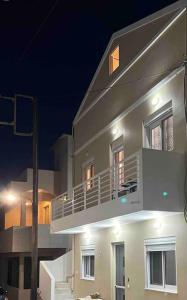 un gran edificio blanco con balcón por la noche en Lydia's cozy house, en Paradeísion