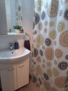 a bathroom with a sink and a shower curtain at Lydia's cozy house in Paradeísion