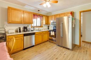 a kitchen with wooden cabinets and a stainless steel refrigerator at Spacious Pocono Lake House Near Skiing and Swimming! in Pocono Lake