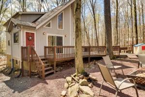 a tiny house with a porch and chairs in the woods at Spacious Pocono Lake House Near Skiing and Swimming! in Pocono Lake