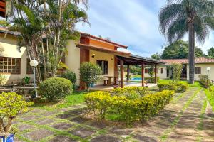 ein Haus mit einem Innenhof mit Bäumen und Pflanzen in der Unterkunft Casa de campo c piscina e natureza em Mairinque SP in Mairinque