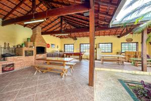 ein Wohnzimmer mit einem Tisch und einem Kamin in der Unterkunft Casa de campo c piscina e natureza em Mairinque SP in Mairinque