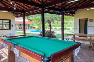 einen Billardtisch auf einer Terrasse mit Pool in der Unterkunft Casa de campo c piscina e natureza em Mairinque SP in Mairinque