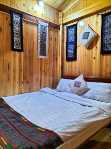 una camera da letto con un letto, pareti e finestre in legno di Sapa Shalom Homestay a Sa Pa