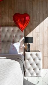 a red heart balloon is hanging above a bed at 7Mirrors in Murjāņi