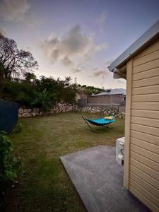 a green hammock sitting in a yard next to a house at Bungalow F2 (pitaya) in Le Moule
