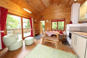 eine Küche und ein Wohnzimmer mit einem Tisch in einer Hütte in der Unterkunft Blockhaus Säuling - Haus Elise Apartments in Füssen