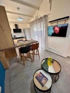 a living room with a flat screen tv on a refrigerator at Bungalow F2 (pitaya) in Le Moule