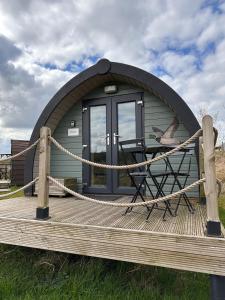 Cabaña pequeña con mesa en una terraza de madera en Rossendale Holiday Cottages, en Rossendale